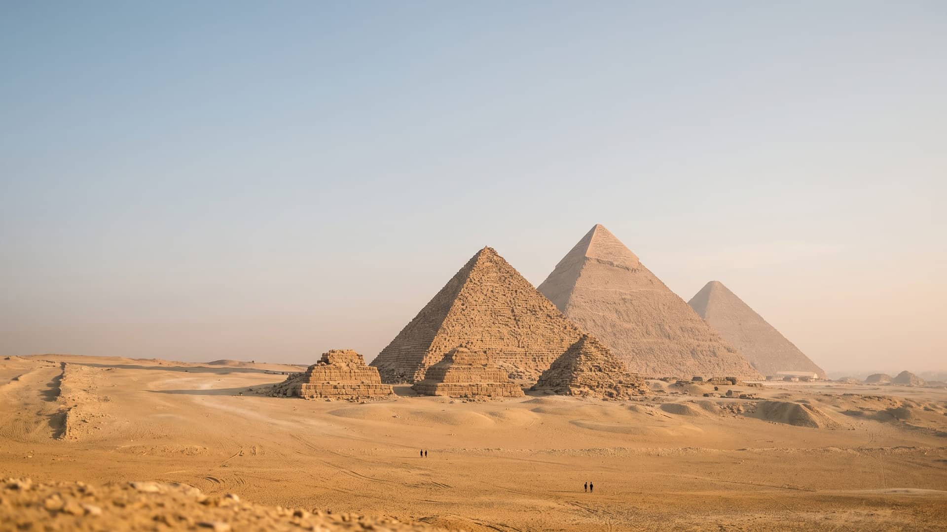 Les pyramides de Gizeh au lever du soleil, vues depuis le plateau désertique